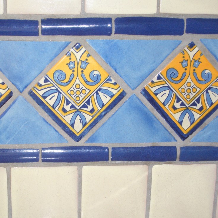 wall decorated with mexican trim tiles including cornice, bullnose and pencil